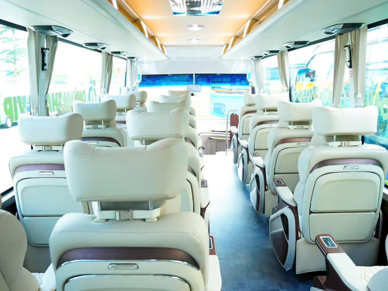 Khoang nội thất Limousine Quỳnh Thanh: ghế ngả bọc sáng màu, bàn ốp gỗ và màn hình