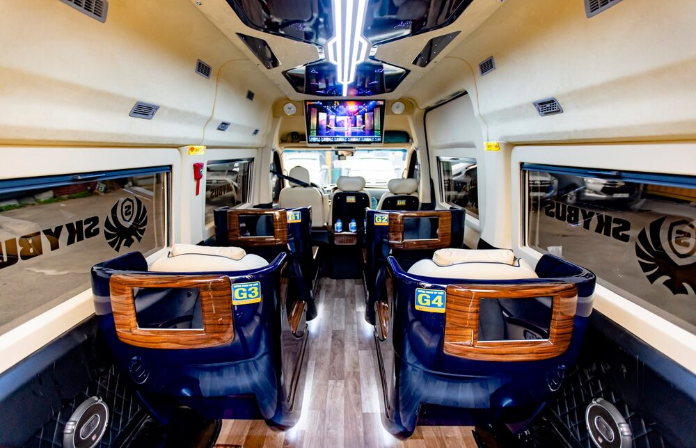 Khoang nội thất Limousine Quỳnh Thanh nhìn dọc lối đi, ghế bọc da và ốp gỗ